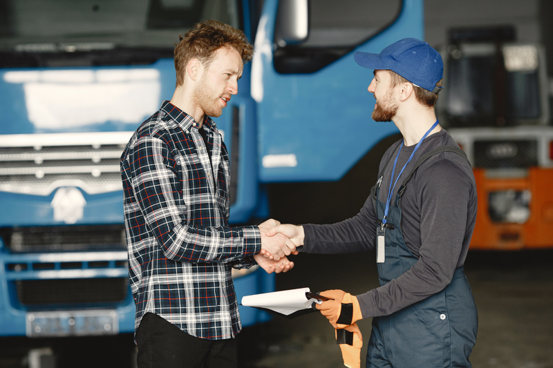 two-guys-talking-about-work-work-in-garage-near-truck-transfer-of-documents-with-goods.jpg